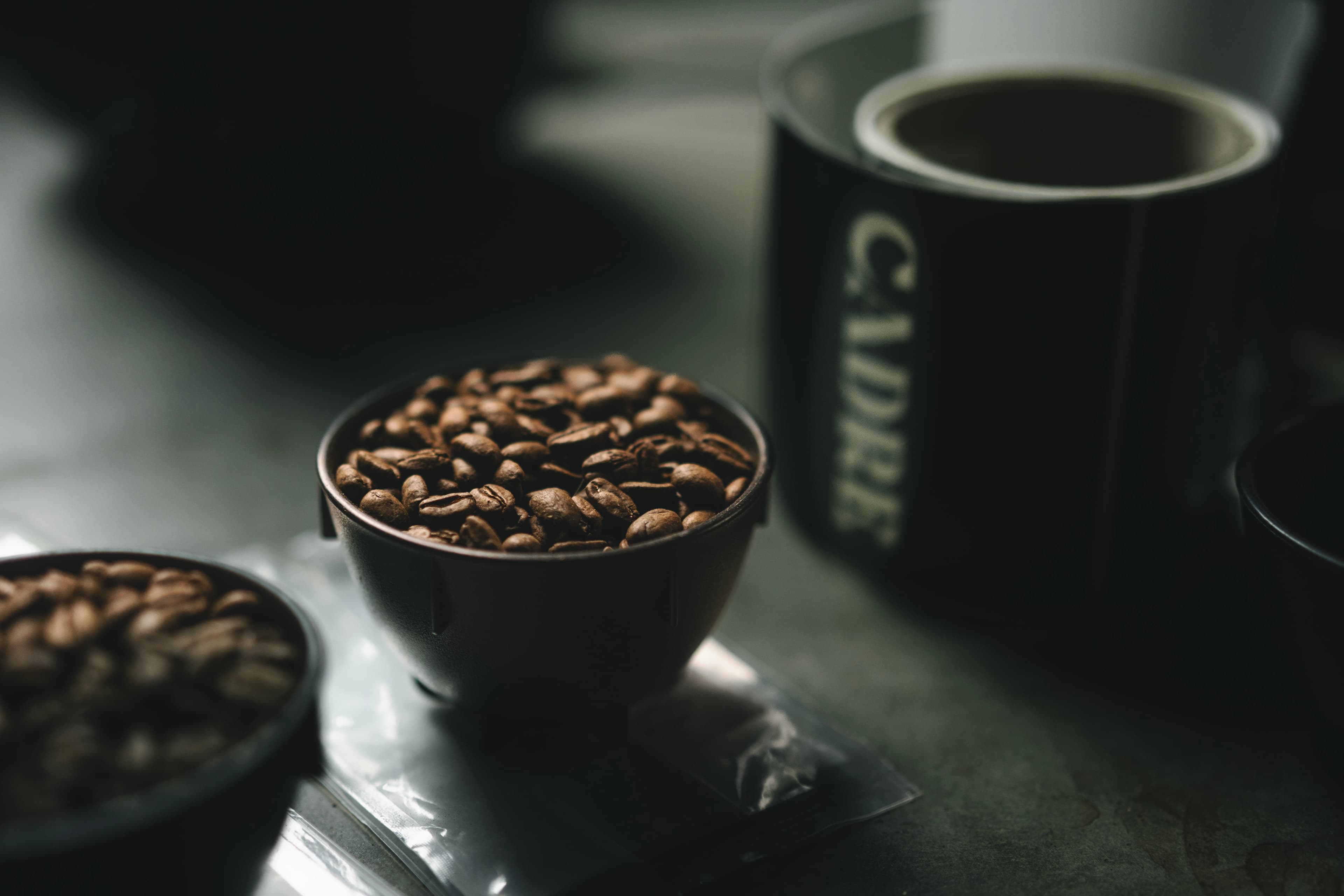 Cupping bowl of beans beside a Cadre branded mug